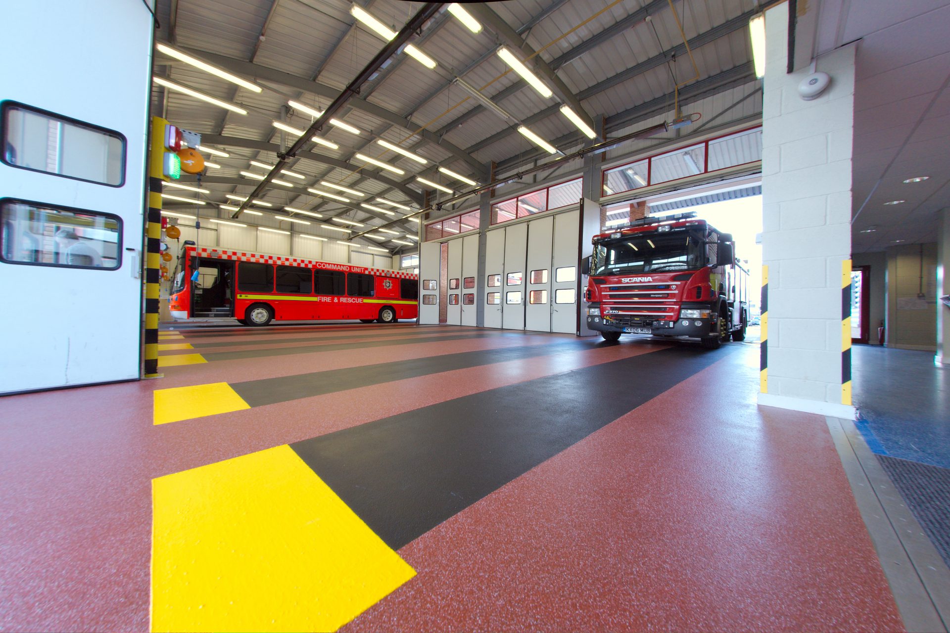 Fire station with red resin flooring and yellow and black bays-Resin Flooring Contractors- Ayslebury Fire Station